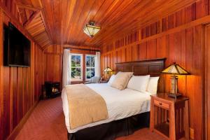 1 dormitorio con 1 cama en una habitación de madera en Noyo Harbor Inn, en Fort Bragg