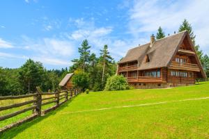 una casa in legno su una collina con una recinzione di Wille Trójca a Trójca