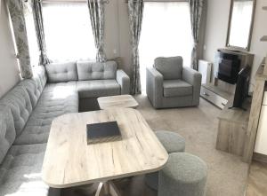 a living room with a table and a couch at Luxury 3 Bedroom Caravan MC37, Shanklin, Isle of Wight in Shanklin