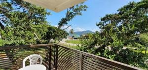 a white chair sitting on a wooden deck with trees at Morada da Figueira in Bombinhas