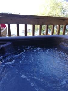 bañera de hidromasaje en una terraza con agua azul en Maison sur la plage, en Grenville-sur-la-Rouge