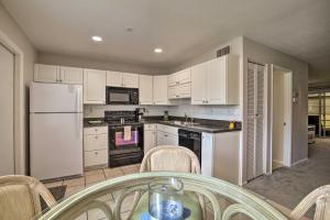 una cocina con electrodomésticos blancos, mesa y sillas en Condo with Pool Access Less Than 4 Miles to Siesta Key Beach, en Sarasota