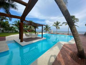 a beach with a pool and a beach chair at Casa del Puerto by MIJ - Beachfront Hotel in Puerto Morelos