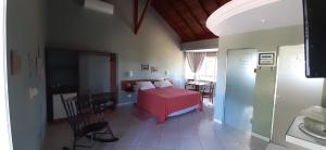 a bedroom with a red bed in a room at Hotel - Pousada 3 Marias in São Pedro