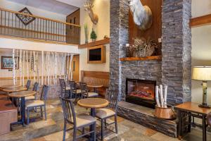 um restaurante com lareira e mesas e cadeiras em Comfort Inn at Thousand Hills em Branson