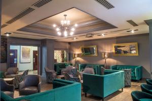 uma sala de espera com cadeiras verdes e um lustre em Hotel Santa Anita a Balderrama Hotel Collection em Los Mochis