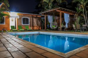 a swimming pool in front of a house at night at Pousada Sonho Meu in Itanhandu