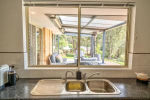 a kitchen sink with a large window above it at Peace Rise, Denmark in Denmark