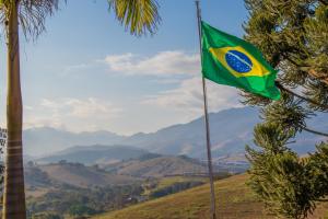 a flag on a hill with mountains in the background at Pousada Sonho Meu in Itanhandu