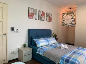バヤンレパスにあるTR Penang House for Large Family Getawaysのベッドルーム1室(ブルーベッド1台、靴2本付)