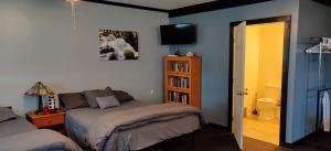 1 dormitorio con 2 camas y TV en la pared en Becker's Private Studio 2 Queen Beds, 1 Futon with a Great Back Yard!, en Auburn