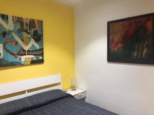 a bedroom with a bed and two paintings on the wall at Villa by the sea - in full relaxation - Air conditioned - Wi-fi in Fontane Bianche