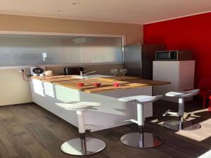 a kitchen with a counter and some stools in it at Villa by the sea - in full relaxation - Air conditioned - Wi-fi in Fontane Bianche