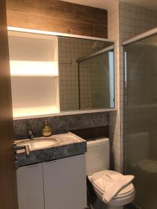 bagno con lavandino, servizi igienici e specchio di Cupe Beach Living Flat a Porto De Galinhas