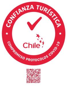 un círculo rojo con las palabras colombia turkish chile logo en Hotel Casa Algarrobo en San Pedro de Atacama