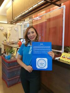 una mujer está sosteniendo una caja azul en The Grand Wipanan Residence en Chiang Mai