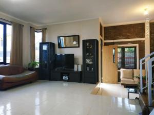 a living room with a couch and a television at The Bridge Villa Punclut in Bandung