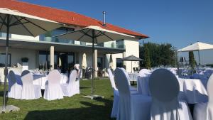 a group of tables with white chairs and umbrellas at CASA Felicita in Unterneukirchen