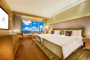 duże łóżko w pokoju z dużym oknem w obiekcie Hotel Okura Macau w mieście Makau