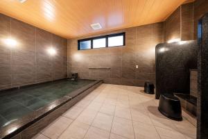 a large bathroom with a bath tub and a window at The Celecton Kurume in Kurume