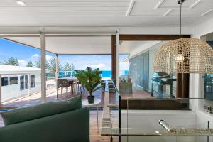een woonkamer met een bank en een glazen tafel bij Seascape in Sunshine Beach
