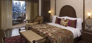 a hotel room with a bed and a balcony at The Khyber Himalayan Resort & Spa in Gulmarg
