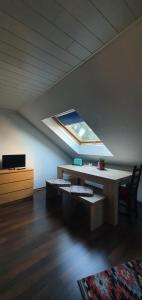 a room with a table and a skylight in a attic at Tulpenoase in Neuendettelsau