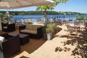 a patio with chairs and tables and an umbrella at Tulpenoase in Neuendettelsau