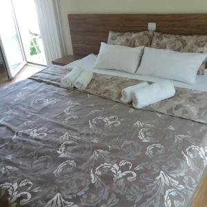 een groot bed met twee handdoeken erop bij Villa Dunja in Kragujevac
