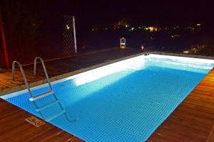 a large swimming pool at night with blue lights at Royal Villa Pedi in Symi