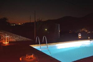 a swimming pool at night with a fence at Royal Villa Pedi in Symi