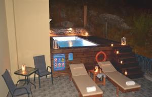 a pool in a building with a table and chairs at Royal Villa Pedi in Symi