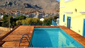 a swimming pool on a deck next to a house at Royal Villa Pedi in Symi