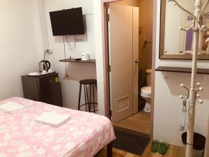 a small room with a bed and a toilet at Dragon XIV in Bangkok