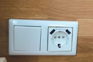 a white electrical outlet on a wooden floor at Hotel Residenz in Düsseldorf