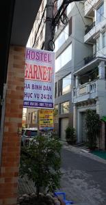 芹苴的住宿－Hostel Garnet，建筑物边有树的标志