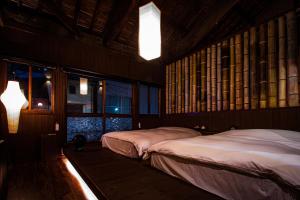 two beds in a room with two windows at MACHIYA-VILLA SEIAN in Fukuoka