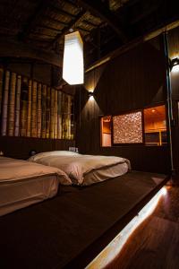 a bedroom with two beds and a light fixture at MACHIYA-VILLA SEIAN in Fukuoka