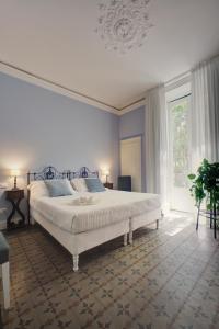 a bedroom with a bed and a large window at Palazzo Pastura B&B and Apartments in Catania