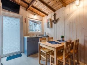 a kitchen with a wooden table with chairs and a sink at Willa Stornia in Jastarnia