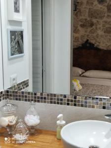 uma casa de banho com um lavatório e um espelho em Ammira em Siracusa