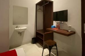 a bathroom with a sink and a desk with a mirror at RedDoorz Syariah At Pucang Anom in Surabaya