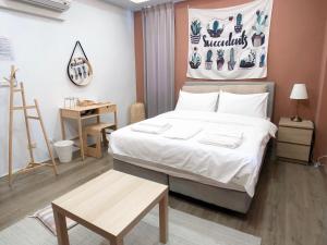 a bedroom with a large bed and a table at Rightday Inn in Dongshan