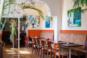 una fila de mesas y sillas en un restaurante en Hotel am Hain en Lübben