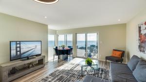 un soggiorno con divano, TV e tavolo di Otter Grotto 1 bed suite - Oceanfront Relaxation a Victoria