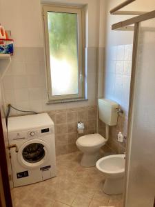 ein Badezimmer mit einem WC und einer Waschmaschine in der Unterkunft Casa Vacanze Kezia in Torrenova