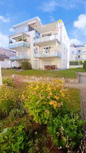 ein großes weißes Gebäude mit Blumen davor in der Unterkunft Deluxe Apartment in Überlingen