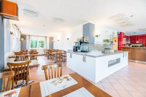 a restaurant with a bar and tables and chairs at My Pension STUTTGART-AIRPORT-MESSE in Leinfelden-Echterdingen