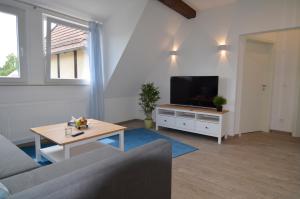 a living room with a couch and a tv at Ferienwohnung Seulberg in Friedrichsdorf