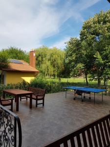 a ping pong table and benches on a patio at Pensiunea Ruxandra la 100 m de Aqua Park Venus in Baile Unu Mai